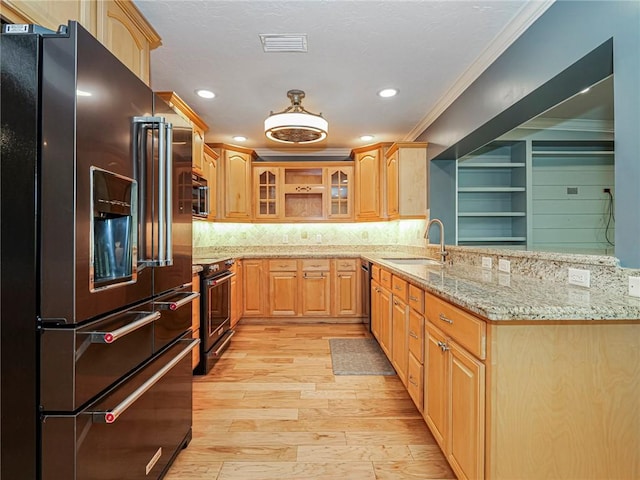 kitchen featuring stainless steel dishwasher, refrigerator with ice dispenser, visible vents, a sink, and range with electric cooktop