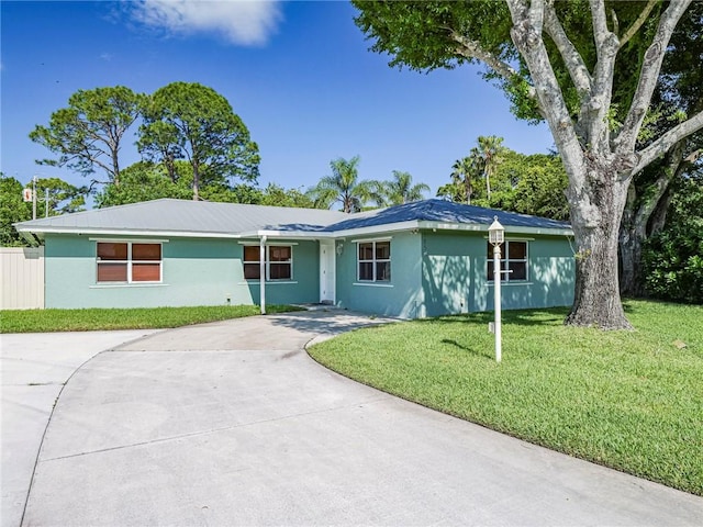 single story home with a front lawn, stucco siding, and concrete driveway