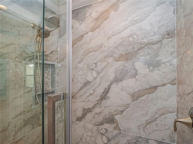 room details with a marble finish shower and ornamental molding