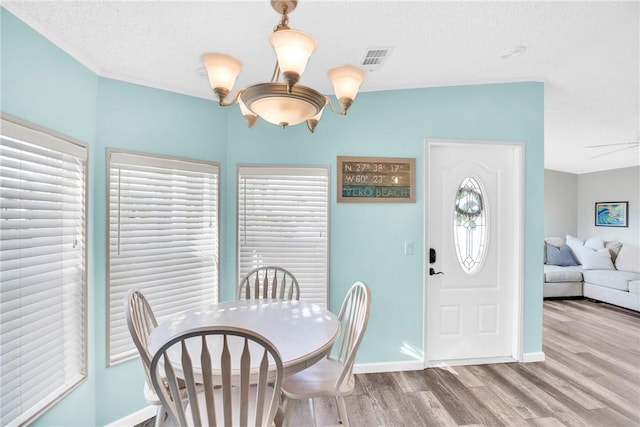860 Pirates Cove Ln, Fort Pierce, FL 34949 - dining room with a notable chandelier, baseboards, a textured ceiling, visible vents, and wood finished floors