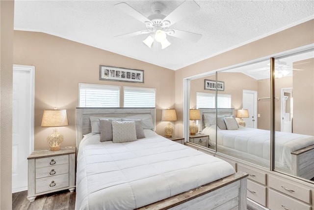 860 Pirates Cove Ln, Fort Pierce, FL 34949 - bedroom with a closet, a ceiling fan, a textured ceiling, wood finished floors, and vaulted ceiling