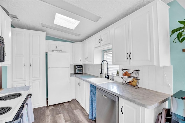 860 Pirates Cove Ln, Fort Pierce, FL 34949 - kitchen featuring white appliances, white cabinets, lofted ceiling, a sink, and wood finished floors