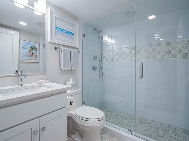 bathroom with toilet, vanity, and walk in shower