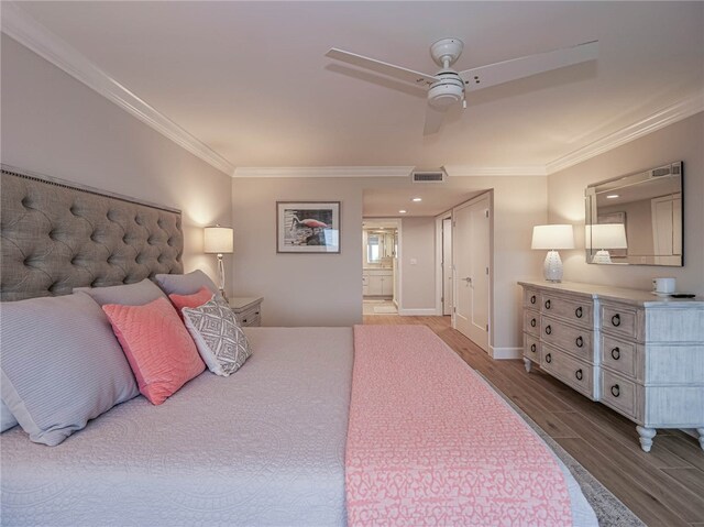 bedroom featuring ensuite bathroom, hardwood / wood-style floors, ceiling fan, and crown molding