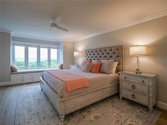 bedroom with dark wood-type flooring, ceiling fan, and crown molding