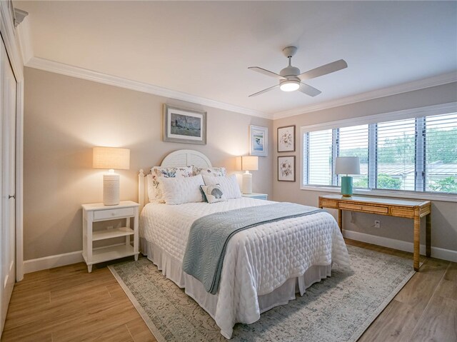 bedroom featuring light hardwood / wood-style floors, ceiling fan, and ornamental molding