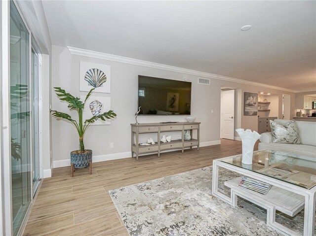 living room with crown molding and light hardwood / wood-style flooring