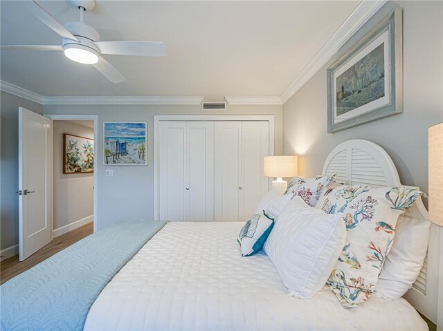 bedroom featuring a closet, wood-type flooring, ceiling fan, and crown molding