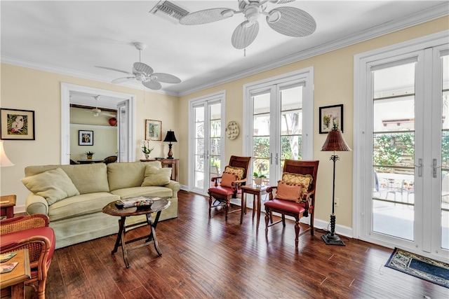 living room with ornamental molding, dark wood-type flooring, and ceiling fan