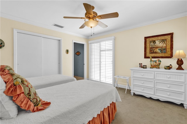 bedroom with a closet, light colored carpet, ceiling fan, and crown molding