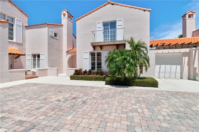 mediterranean / spanish-style home with a garage and a balcony