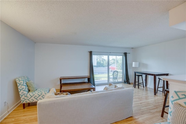 1845 Robalo Dr Unit 101D, Vero Beach, FL 32960 - living area with light wood-type flooring, a textured ceiling, and baseboards