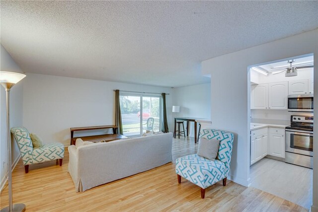 1845 Robalo Dr Unit 101D, Vero Beach, FL 32960 - living room featuring light wood finished floors, a textured ceiling, and baseboards