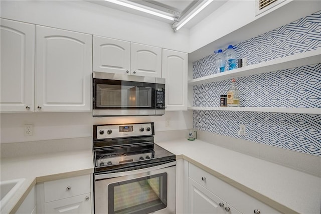 1845 Robalo Dr Unit 101D, Vero Beach, FL 32960 - kitchen with stainless steel appliances, white cabinetry, and light countertops