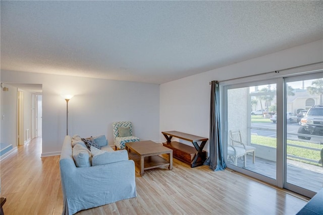1845 Robalo Dr Unit 101D, Vero Beach, FL 32960 - living area featuring light wood-style floors, a textured ceiling, and baseboards