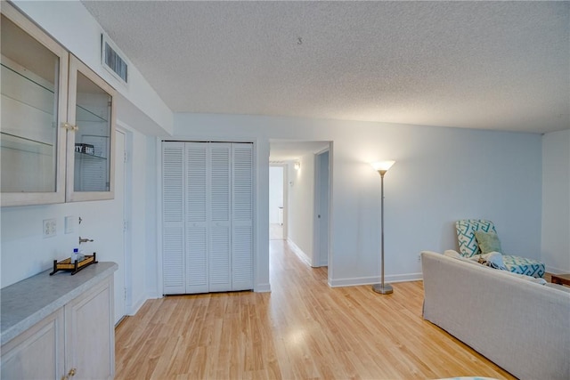 1845 Robalo Dr Unit 101D, Vero Beach, FL 32960 - corridor featuring a textured ceiling, light wood-style floors, and baseboards