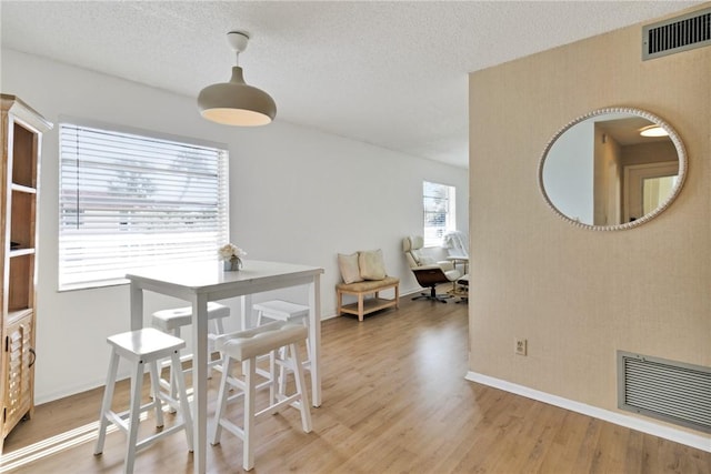 dining room featuring hardwood / wood-style flooring and a textured ceiling