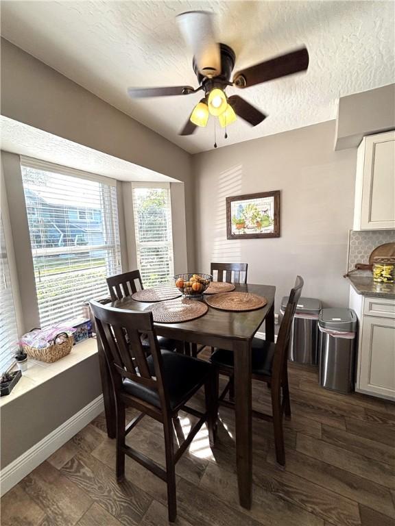 dining area with ceiling fan, dark hardwood / wood-style floors, and a textured ceiling