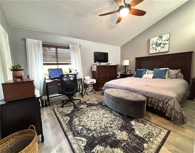 bedroom with ceiling fan, vaulted ceiling, light hardwood / wood-style flooring, and a textured ceiling