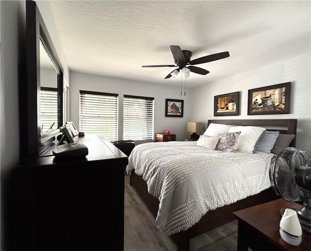 bedroom with dark hardwood / wood-style flooring, a textured ceiling, and ceiling fan