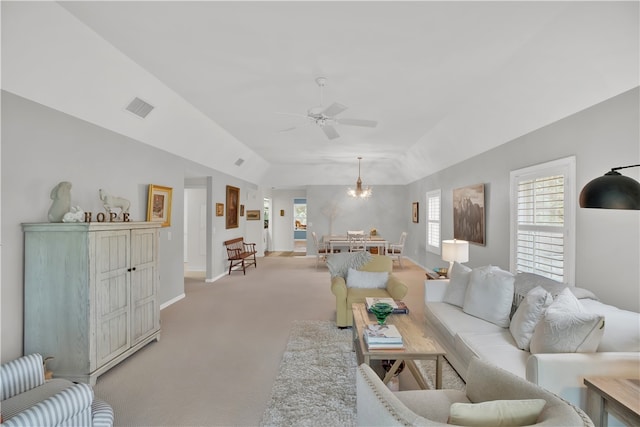 carpeted living room featuring ceiling fan with notable chandelier