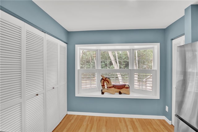 interior space with hardwood / wood-style floors and stainless steel refrigerator