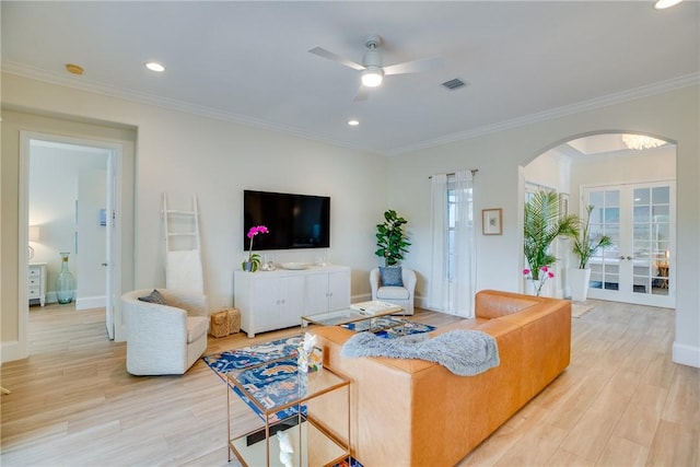 living room with crown molding, french doors, ceiling fan, and light wood-type flooring