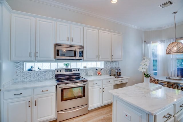 kitchen featuring hanging light fixtures, tasteful backsplash, light hardwood / wood-style flooring, white cabinets, and appliances with stainless steel finishes