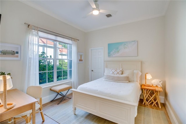 bedroom featuring light wood-type flooring, ceiling fan, and crown molding