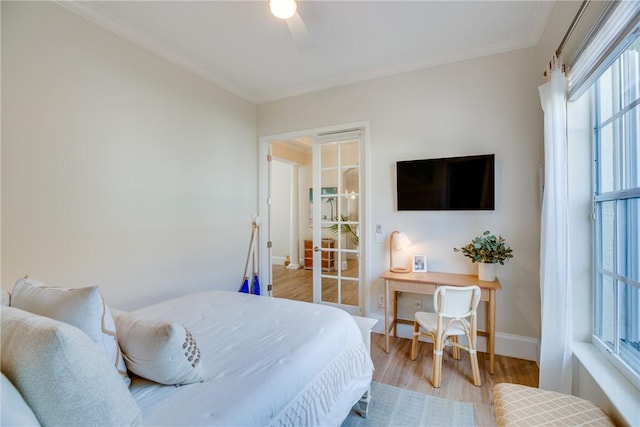 bedroom with ceiling fan, crown molding, and light hardwood / wood-style flooring