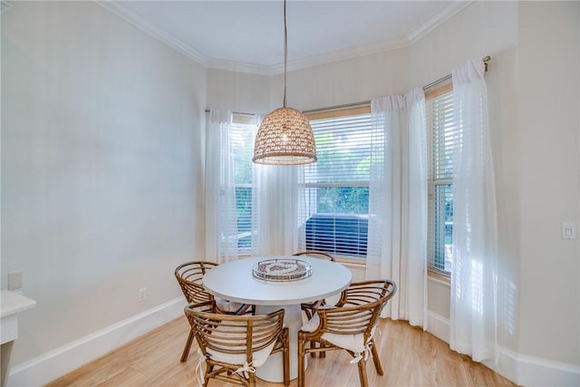 dining space with wood-type flooring, crown molding, and a notable chandelier