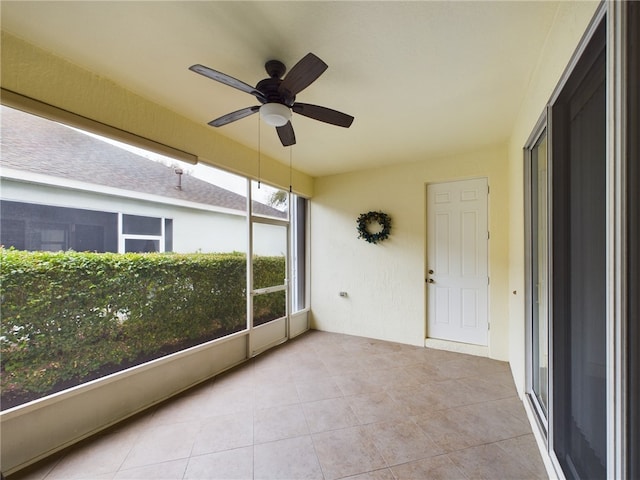 unfurnished sunroom with a ceiling fan