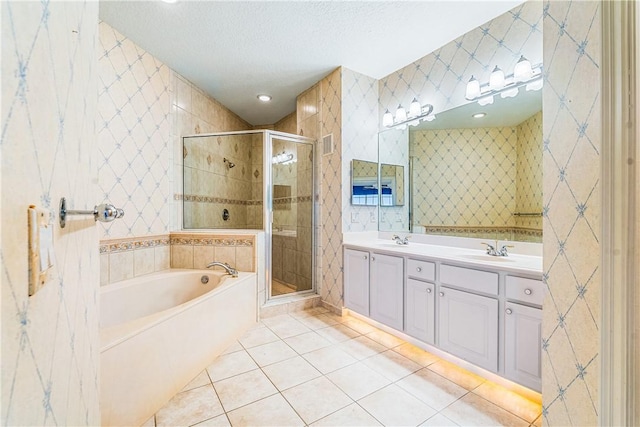 bathroom featuring a textured ceiling, plus walk in shower, tile patterned floors, and vanity