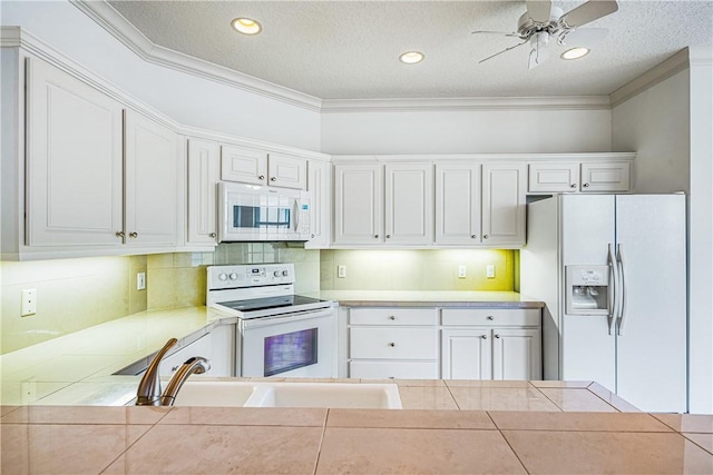 kitchen with white appliances, white cabinetry, and ornamental molding