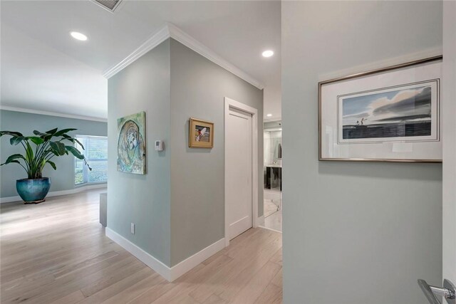 corridor featuring recessed lighting, light wood-type flooring, baseboards, and crown molding