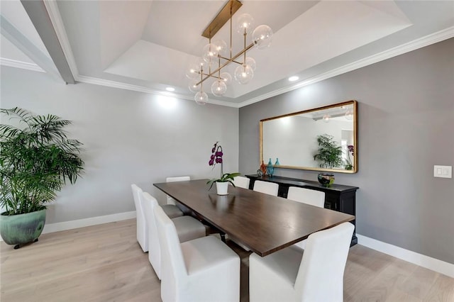 dining room featuring crown molding, baseboards, a tray ceiling, recessed lighting, and light wood-style floors