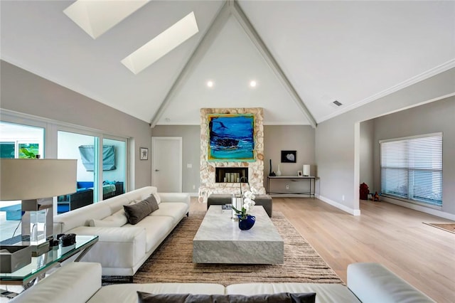 living area with a skylight, plenty of natural light, light wood-style flooring, and a fireplace