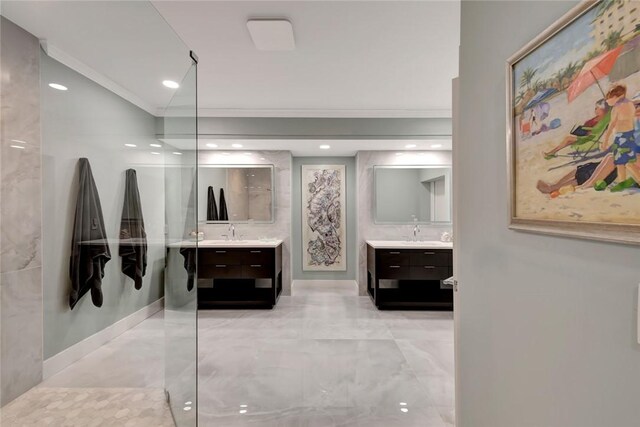 bathroom with ornamental molding, two vanities, a walk in shower, and a sink