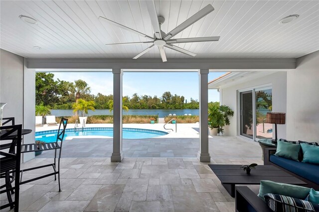 outdoor pool featuring an outdoor living space, a patio, ceiling fan, and a water view