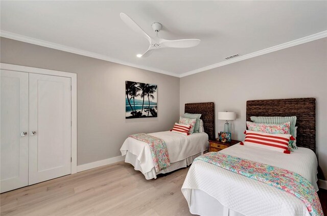 bedroom with baseboards, ceiling fan, ornamental molding, light wood-style floors, and a closet