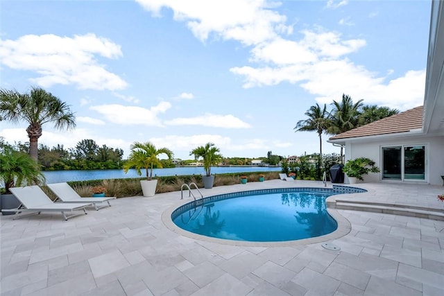 outdoor pool featuring a patio and a water view