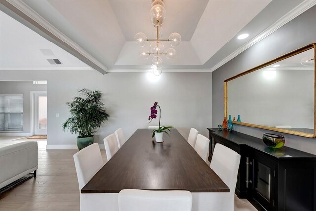 dining area with visible vents, baseboards, light wood-type flooring, ornamental molding, and an inviting chandelier