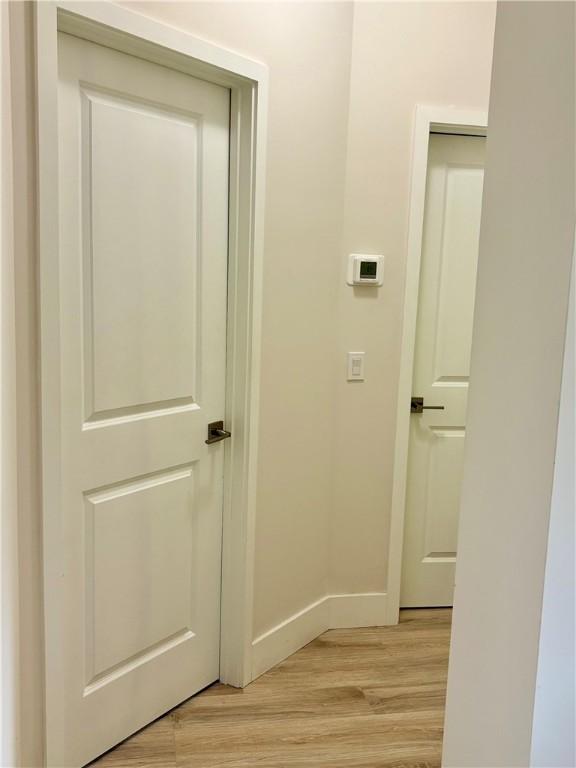 hallway with light hardwood / wood-style floors