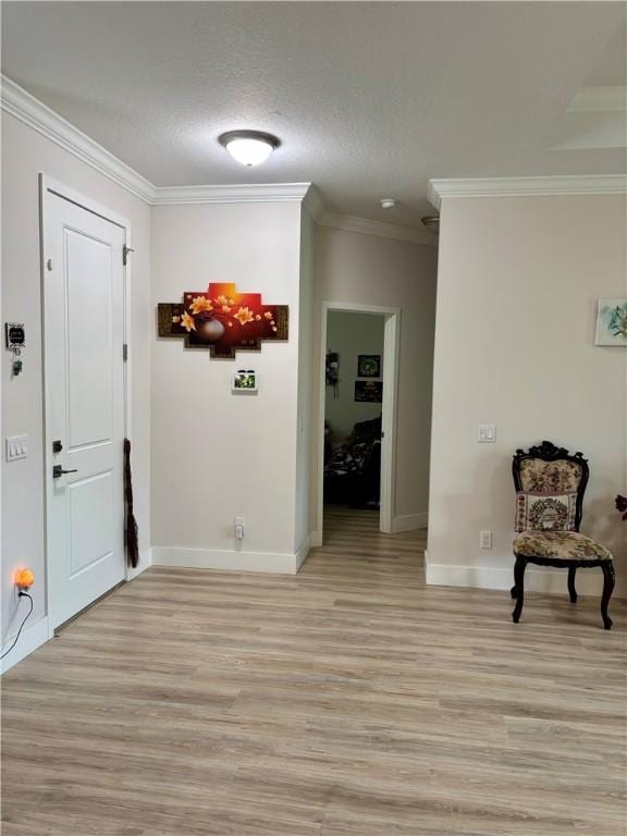 interior space with light hardwood / wood-style flooring, ornamental molding, and a textured ceiling