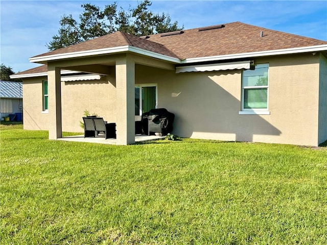 rear view of house featuring a patio and a yard