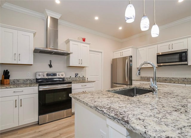 kitchen featuring appliances with stainless steel finishes, white cabinets, hanging light fixtures, light stone countertops, and wall chimney range hood