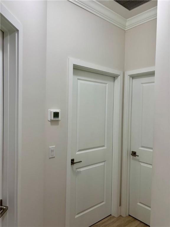 interior space featuring crown molding and light hardwood / wood-style flooring