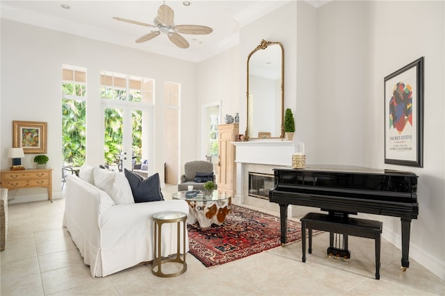 sitting room with ceiling fan, french doors, light tile patterned floors, and ornamental molding