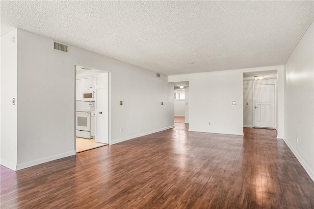 unfurnished living room featuring wood finished floors, a textured ceiling, and baseboards