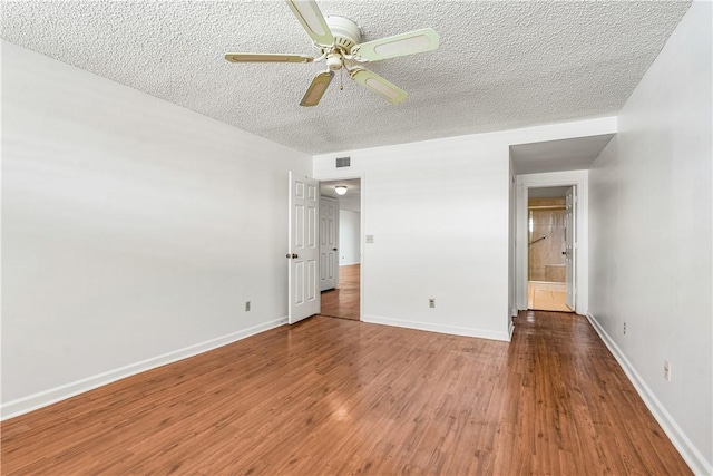 unfurnished bedroom featuring a textured ceiling, wood finished floors, baseboards, and ceiling fan